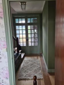 un couloir avec une porte verte et un tapis dans l'établissement Maison Huitlala, à Lavaufranche