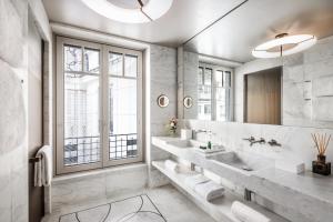 a bathroom with two sinks and a large mirror at Mandarin Oriental Lutetia, Paris in Paris