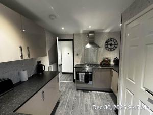 a kitchen with a sink and a stove top oven at Entire 2 bed modern apartment in Nantwich +26 photos