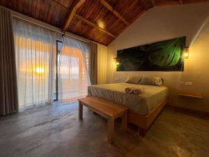a bedroom with a bed with a bench and a large window at La Cabane D Eté in Port Mathurin +73 photos