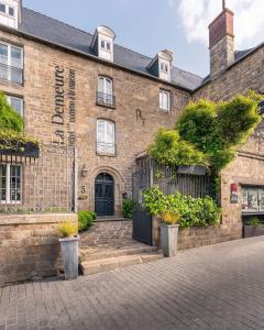 un vecchio edificio di mattoni con una porta nera di La Demeure a Guingamp Altre 4 foto