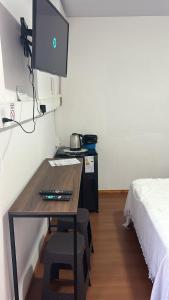 een kamer met een bureau, een bed en een televisie bij Las marias in Paso de los Libres