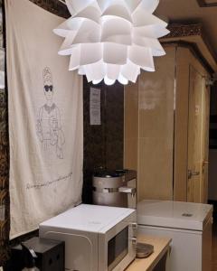 a large white chandelier hanging over a microwave at Bomnal Stay 봄날스테이 in Samgong