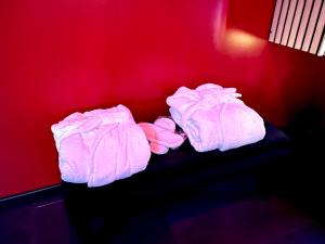 twee dekens liggen op een tafel in een rode muur bij Redroom, Spa, Sauna, cheminée, romantique pour 2 in Quimperlé +18 foto's