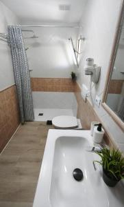une salle de bains avec un lavabo blanc et des toilettes dans l'établissement Take it easy in Corralejo, à Corralejo 12 autres photos