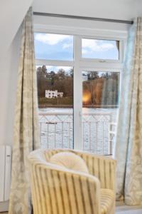 a room with a window with a chair and a chair at 5 Rushbrooke Hotel Apartments Cobh County Cork in Cobh