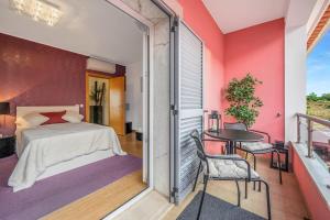 een slaapkamer met een bed en een tafel op een balkon bij Elyra Cascais in Alcabideche +56 foto's
