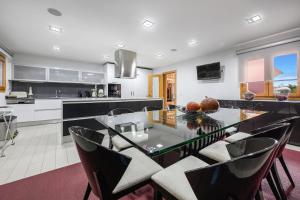 een keuken met een glazen tafel en een aantal stoelen bij Elyra Cascais in Alcabideche