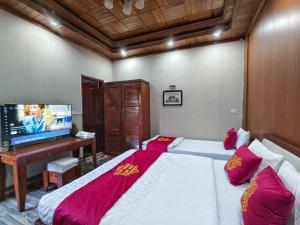 a bedroom with two beds and a flat screen tv at Xumi Motel in Hanoi