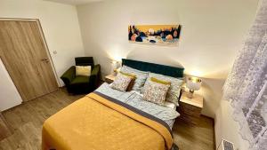 una piccola camera da letto con un letto e una sedia di Šumava ski apartment under Zadov 70m2 a Stachy