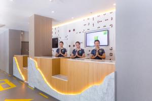 曼谷曼谷素坤逸50号宜必思尚品酒店的三人坐在柜台上