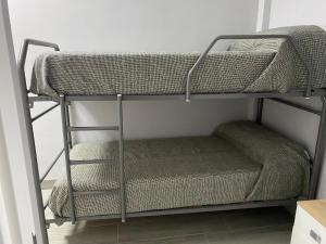 Etagenbett in einem Zimmer mit einer Leiter in der Unterkunft Miamar in Sevilla