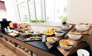 a buffet with bowls of food on a table at Econnomy Adler in Golling an der Salzach +3 photos