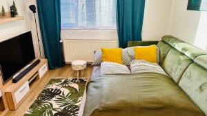 un soggiorno con un divano e una televisione di Šumava ski apartment under Zadov 70m2 a Stachy