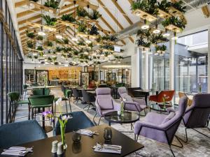 een restaurant met paarse stoelen en tafels bij Mercure Tokaj Center in Tokaj