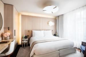 a hotel room with a large bed and a desk at Mandarin Oriental Lutetia, Paris in Paris