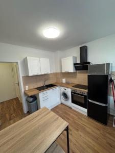 una cucina con mobili bianchi e un frigorifero nero di Apartment a Gelsenkirchen