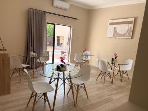 a room with white chairs and tables and a window at Cathy & P Guesthouse in Hartbeespoort