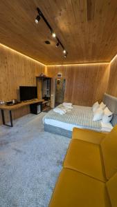 una camera da letto con un letto, una scrivania e una televisione di SarySai Boutique Hotel a Almaty