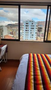 a room with a bed and a large window at Plaza murillo in La Paz