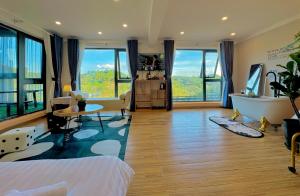 un grand salon avec une baignoire et une grande fenêtre dans l'établissement Pine Forest House Dalat, à Xuan An