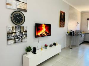 a living room with a fireplace on a wall at Travellers paradise in Palatswe