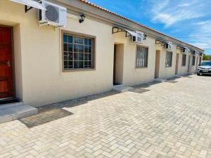a building with a red door and a parking lot at Travellers paradise in Palatswe