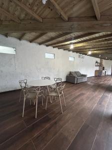 een tafel en stoelen in een kamer met een bank bij Gamboa House in Garopaba