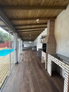 een open veranda met een houten plafond en een zwembad bij Gamboa House in Garopaba