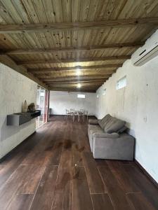 een woonkamer met een bank, een tafel en stoelen bij Gamboa House in Garopaba