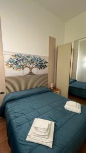 a bedroom with a blue bed with towels on it at HeraDea in Crotone