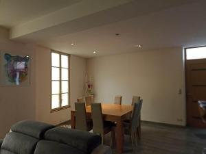 a dining room with a table and chairs and a couch at Mon Jardin Secret in Maligny