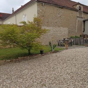 a building with a table and a bench in a yard at Mon Jardin Secret in Maligny