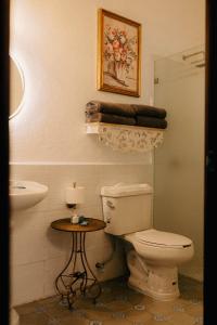 een badkamer met een toilet, een wastafel en een tafel bij Hotel Boutique El Rosario in Teapa