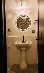 een badkamer met een wastafel en een spiegel bij Hotel Boutique El Rosario in Teapa