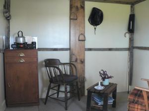 une chambre avec une chaise, une armoire et une table dans l'établissement The Old Shepherd, à Masterton