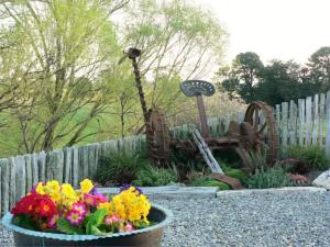un jardin avec des fleurs dans un bol à côté d'une clôture dans l'établissement The Old Shepherd, à Masterton