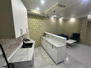 a kitchen with white cabinets and a table and a couch at Hotel Horizont! in Batumi +74 photos