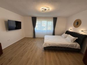 a bedroom with a bed and a flat screen tv at Casa Romanța in Cehu Silvaniei