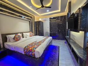 a bedroom with a bed and a ceiling fan at HOTEL REAL Inn in Muzaffarpur