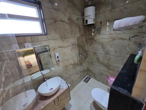 a bathroom with a sink and a toilet and a sink at HOTEL REAL Inn in Muzaffarpur +21 photos