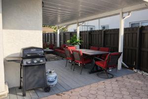 a patio with a table and chairs and a grill at Summer Retreat House in Fort Lauderdale