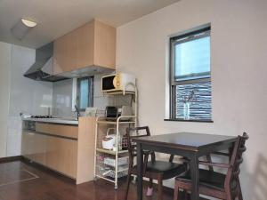 a small kitchen with a table and a table and chairs at Tsurumi Green Base 2LDK in Osaka