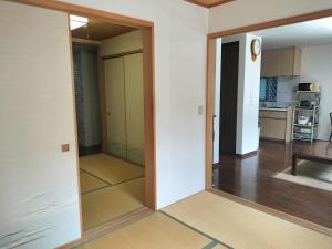a hallway with a mirror in a living room at Tsurumi Green Base 2LDK in Osaka
