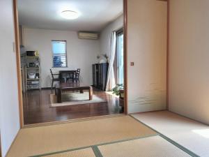 an open door to a living room with a table at Tsurumi Green Base 2LDK in Osaka