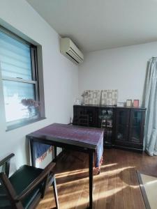 a living room with a table and a window at Tsurumi Green Base 2LDK in Osaka
