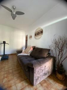 a living room with a couch and a ceiling fan at Casa com piscina em Peruíbe in Peruíbe