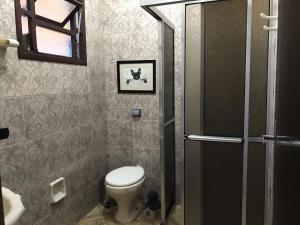 a small bathroom with a toilet and a shower at Casa com piscina em Peruíbe in Peruíbe +8 photos