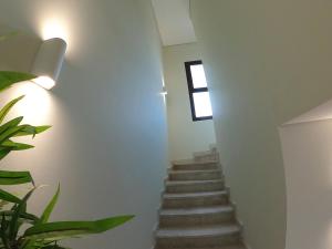 een trap met witte muren en een raam bij The Beach House by JS in Muscat +12 foto's