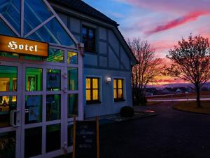 een gebouw met een bord voor de zonsondergang bij Genusshotel Rhönblick in Ostheim